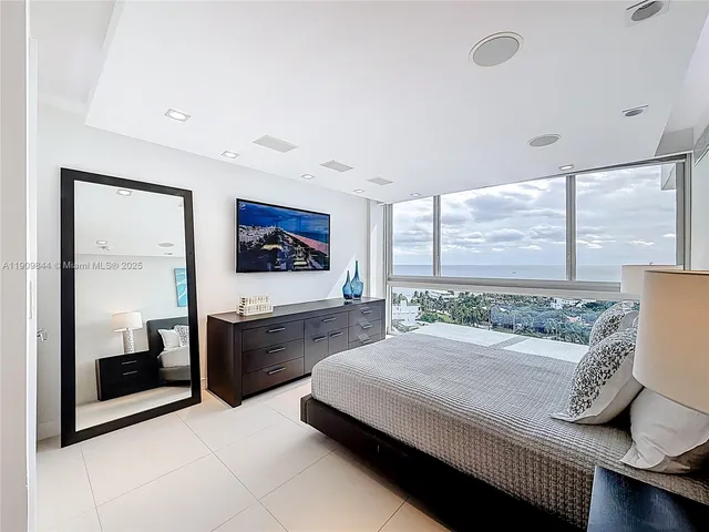 a bedroom with a large bed and a large window