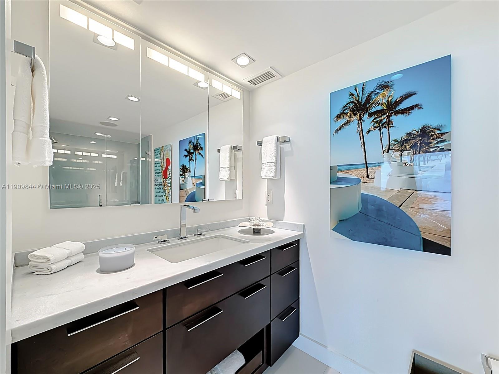 2715 North Ocean Boulevard, Unit 15D Fort Lauderdale, FL 33308 - Photo 26 of 57 a bathroom with a granite countertop sink a large mirror and a shower