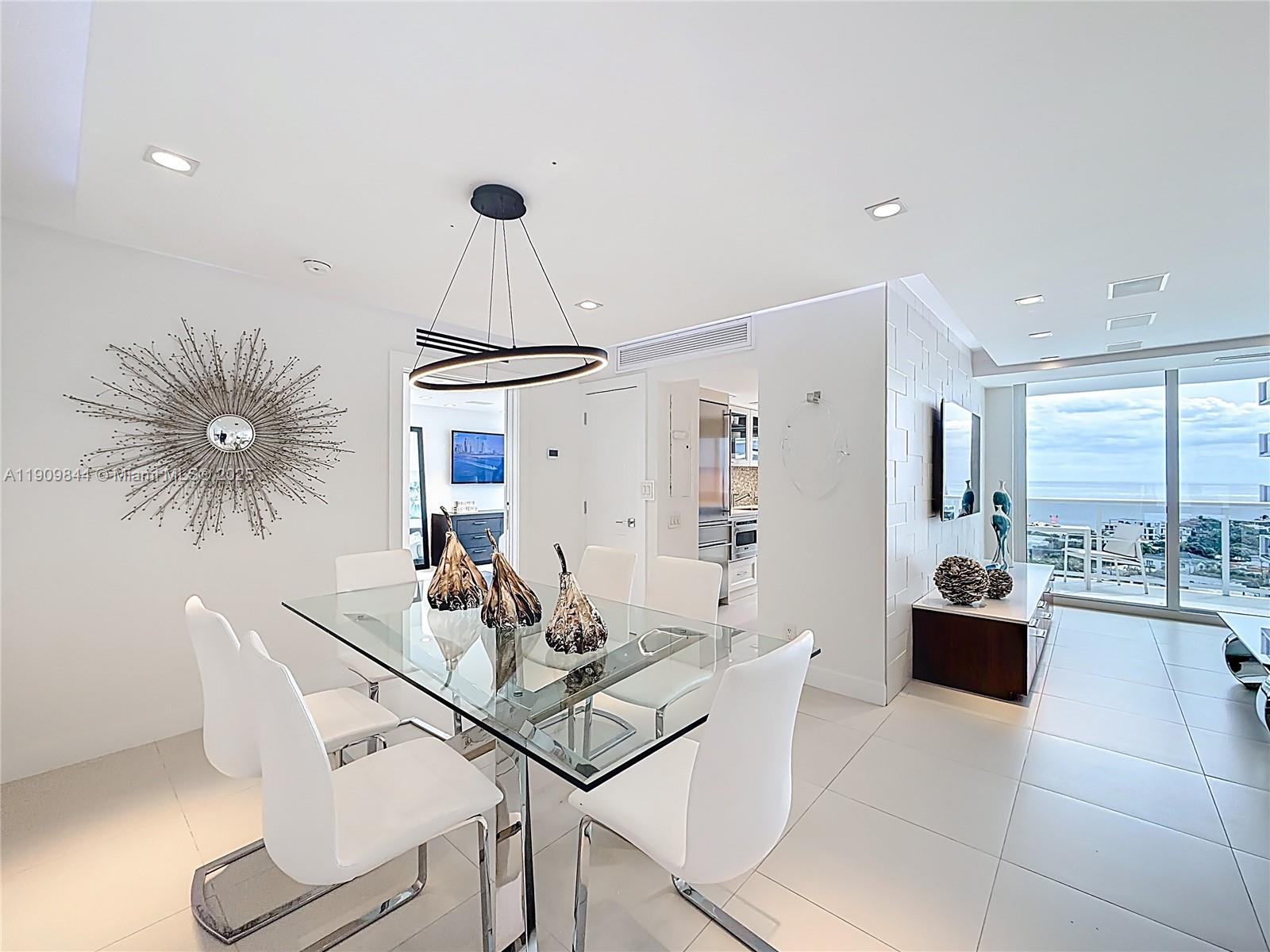 2715 North Ocean Boulevard, Unit 15D Fort Lauderdale, FL 33308 - Photo 10 of 57 a living room with furniture a chandelier and kitchen view