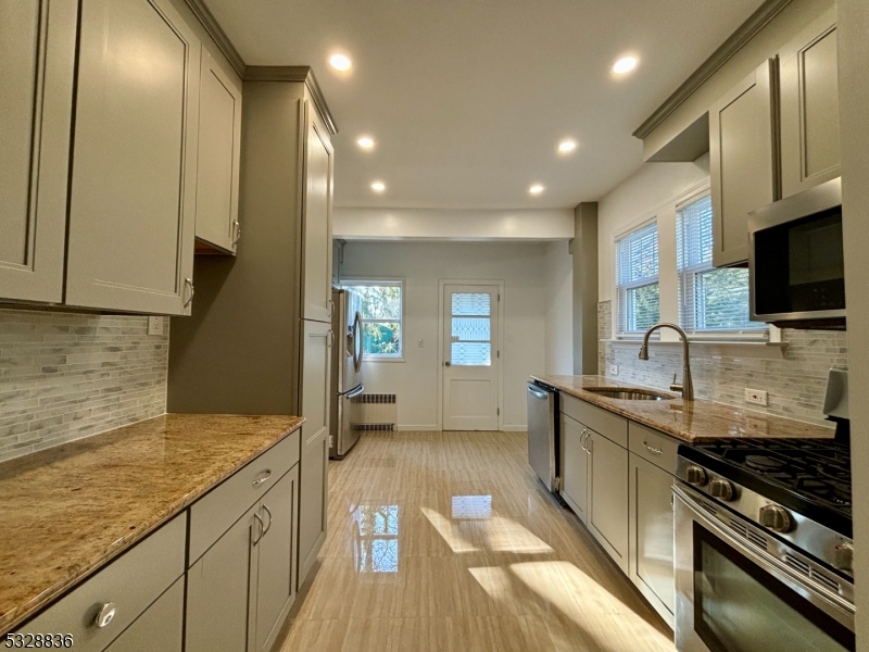 a kitchen with stainless steel appliances a sink stove and cabinets