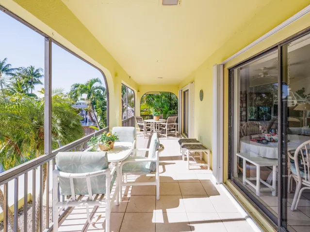 a view of a chairs and table in patio with a small yard