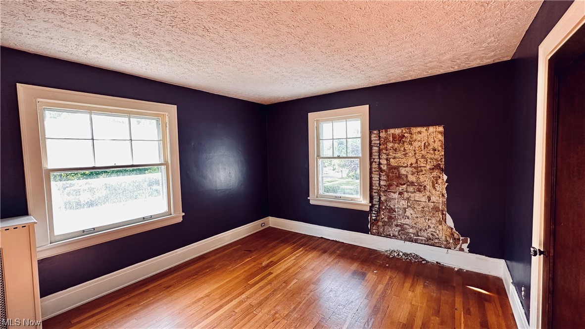 2927 Huntington Road Cleveland, OH 44120 - Photo 9 of 12 Wood floored spare room featuring a textured ceiling