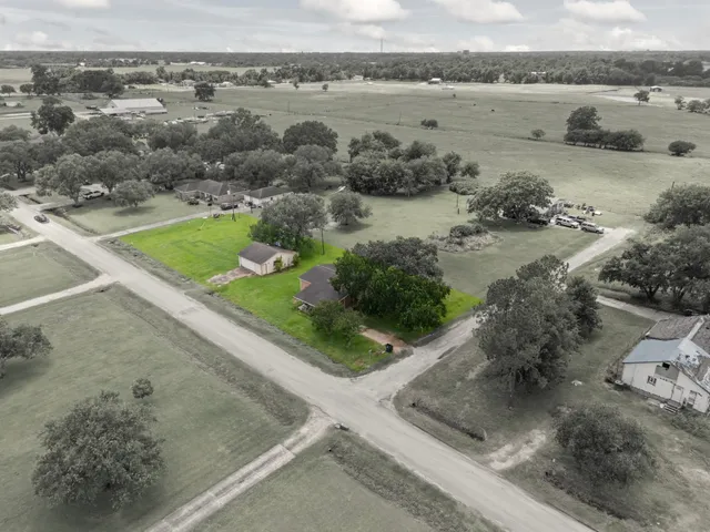an aerial view of a house with a yard and lake view