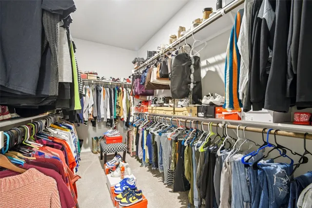a view of walk in closet with clothes