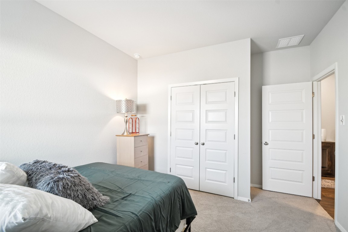 5525 Sacra Cove Austin, TX 78747 - Photo 14 of 20 a bedroom with a bed and cabinets