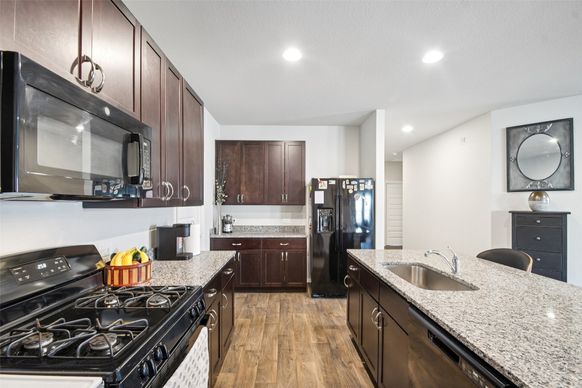 5525 Sacra Cove Austin, TX 78747 - Photo 6 of 20 a kitchen with stainless steel appliances granite countertop a sink stove and refrigerator