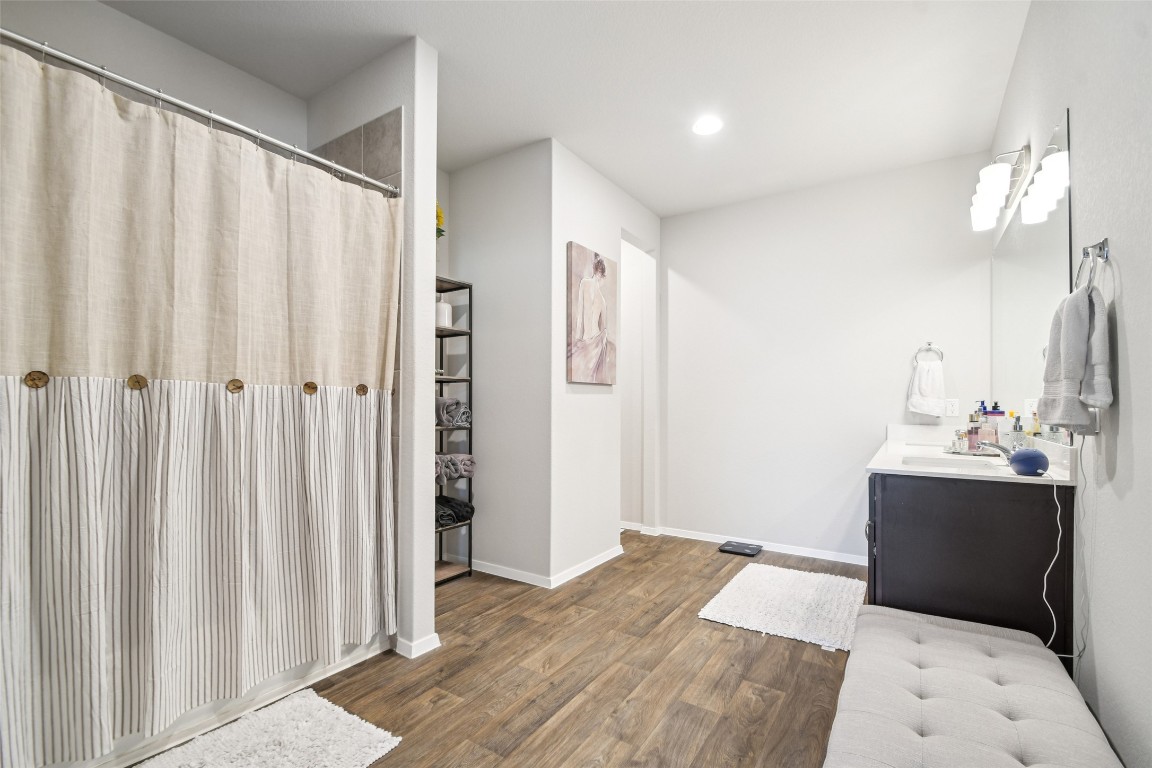5525 Sacra Cove Austin, TX 78747 - Photo 9 of 20 a view of a bedroom with wooden floor and windows
