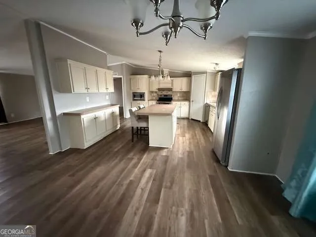 a view of a kitchen with kitchen island wooden floor center island and stainless steel appliances