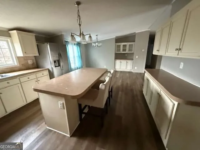 a kitchen with kitchen island a counter space a sink appliances and cabinets