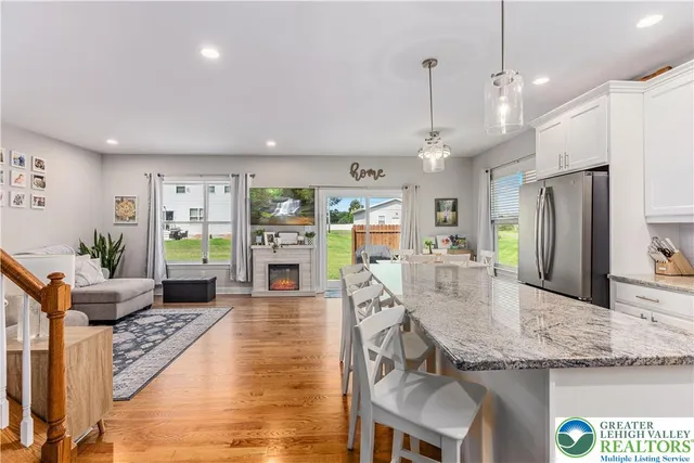 a large kitchen with granite countertop a large counter top space a sink stainless steel appliances and cabinets