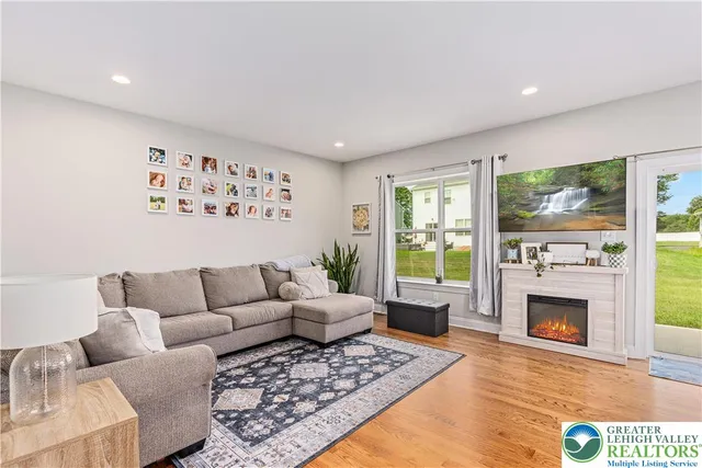 a living room with furniture a flat screen tv and a fireplace