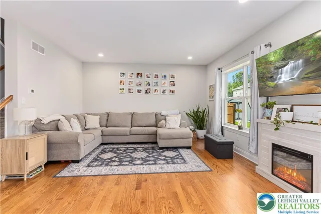 a living room with furniture hard wood floor and a fireplace