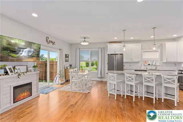 a dining hall with stainless steel appliances kitchen island granite countertop a dining table chairs and granite counter tops