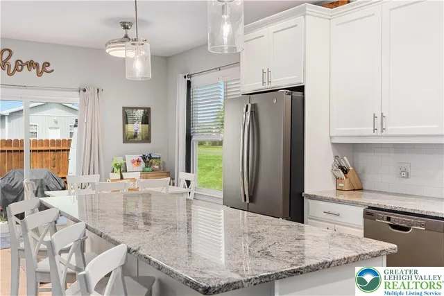 a kitchen with stainless steel appliances granite countertop a sink a refrigerator and a stove