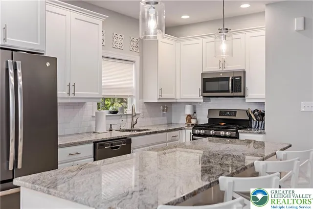 a kitchen with stainless steel appliances granite countertop a refrigerator a stove top oven a sink and dishwasher