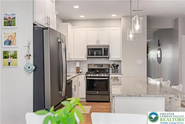 a kitchen with kitchen island a counter top space stainless steel appliances and cabinets