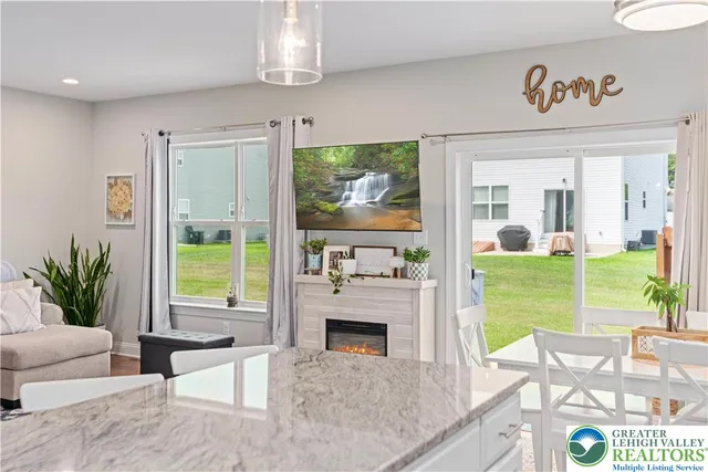 a living room with furniture floor to ceiling window and a fireplace