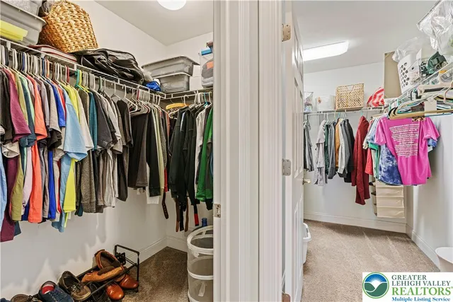 a view of walk in closet with clothes and shoes