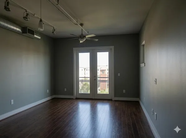 an empty room with wooden floor and windows