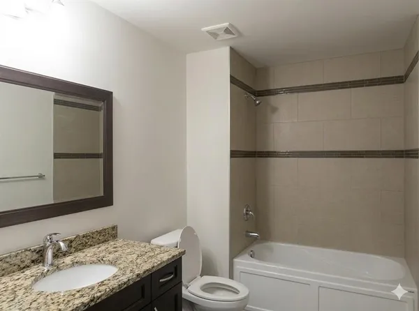 a bathroom with a granite countertop sink toilet and shower