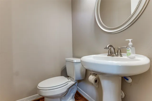 a bathroom with a toilet a sink and a mirror