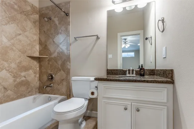 a bathroom with a granite countertop toilet a sink and a bathtub