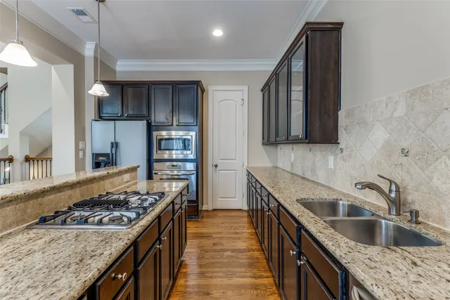 a kitchen with stainless steel appliances granite countertop a sink stove and refrigerator