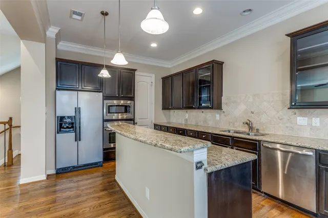 a kitchen with granite countertop a sink and stainless steel appliances