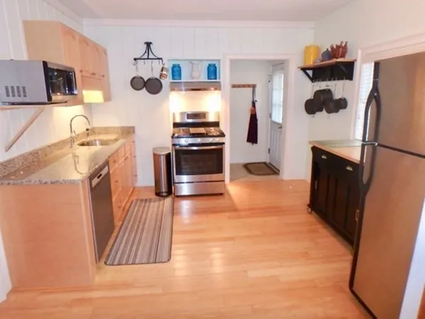 a kitchen with stainless steel appliances granite countertop a refrigerator a stove and a sink