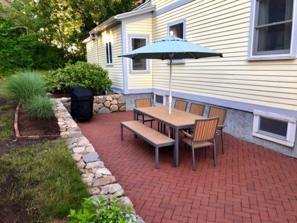 5 Laurel Avenue Oak Bluffs, MA 02557 - Photo 23 of 25 a view of a patio with a table and chairs and potted plants
