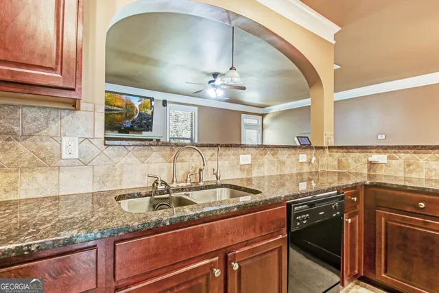 a kitchen with granite countertop a sink stainless steel appliances and cabinets