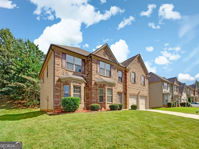 a view of a big house with a big yard and large trees