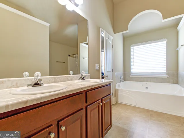 a bathroom with a tub sink and mirror