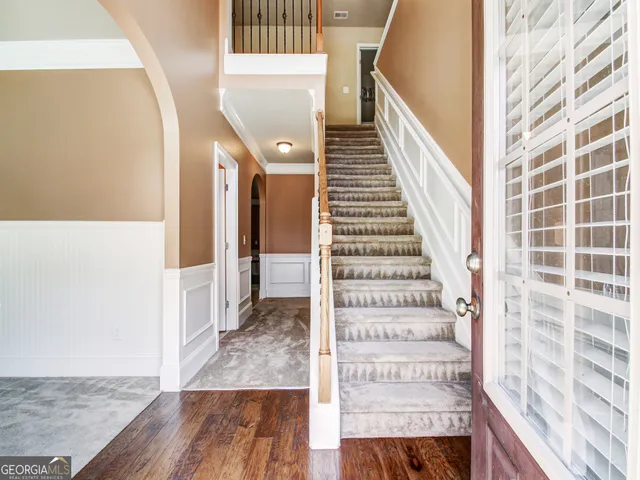 a view of a hallway with wooden floor and entryway
