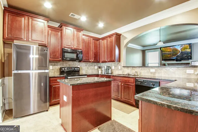 a kitchen with stainless steel appliances granite countertop a sink stove microwave and refrigerator
