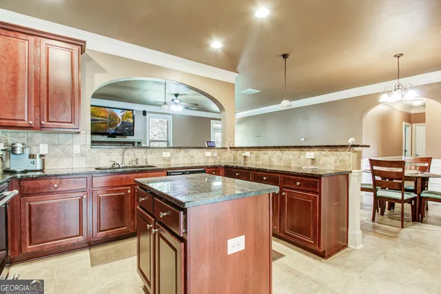 a kitchen with stainless steel appliances granite countertop a stove a sink and a microwave