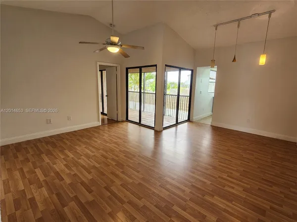 a view of a room with wooden floor and chandelier