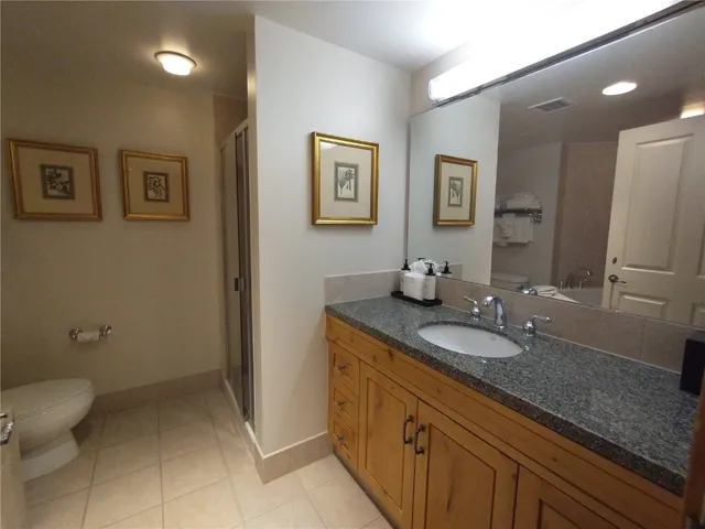a bathroom with a granite countertop sink a toilet and mirror