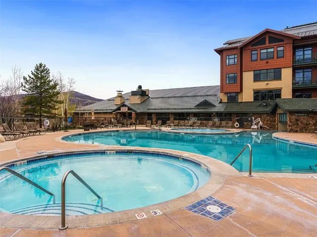 a view of a swimming pool with lawn chairs and couches