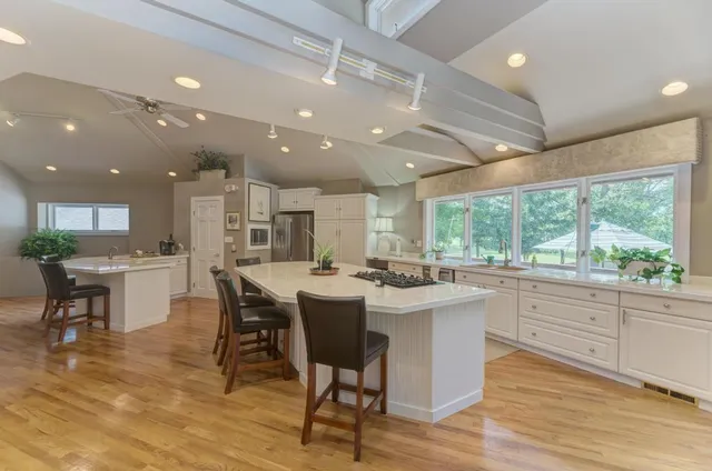 a large kitchen with kitchen island a dining table and chairs