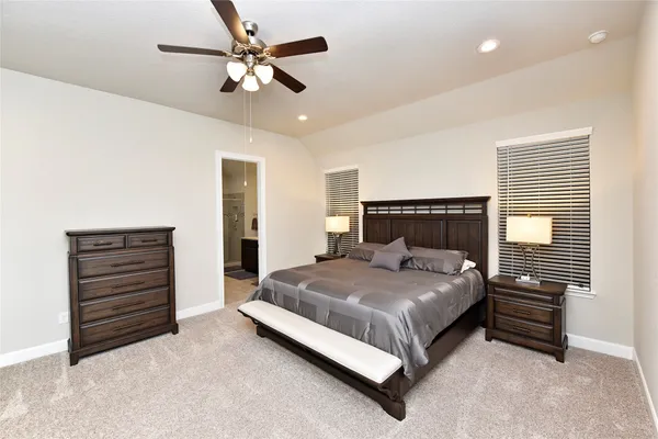 a bedroom with a large bed and a chandelier