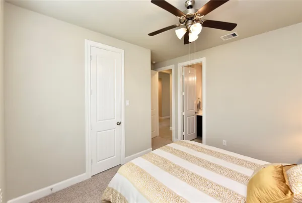a bedroom with a bed and a ceiling fan