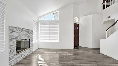 a view of an empty room with a fireplace and a window