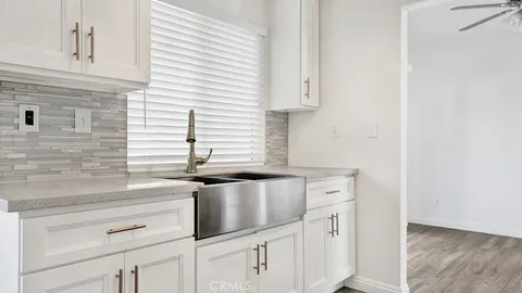 a kitchen with granite countertop white cabinets and white appliances