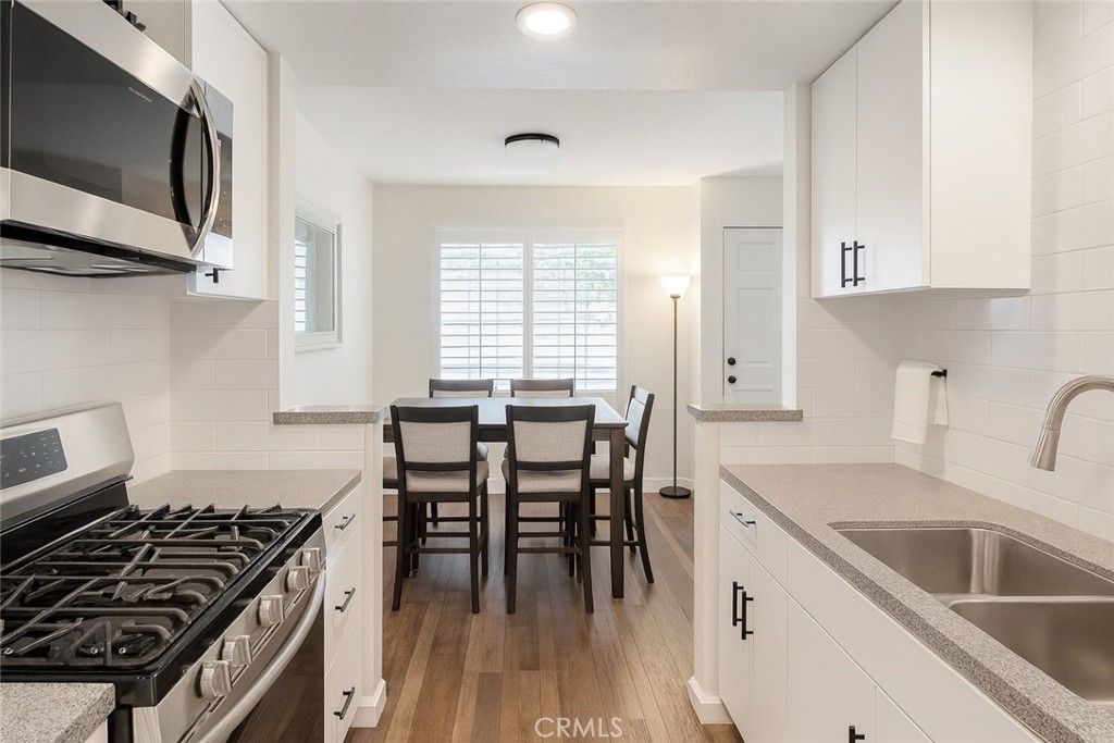 2323 South Cutty Way Anaheim, CA 92802 - Photo 4 of 26 a kitchen with a stove a sink and a microwave
