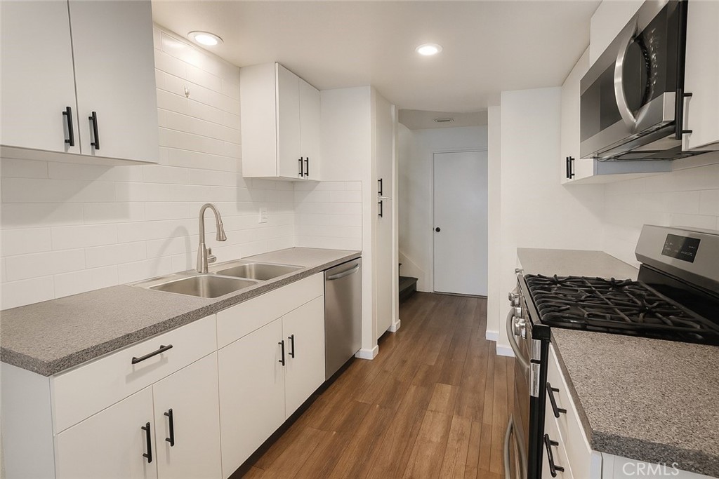2323 South Cutty Way Anaheim, CA 92802 - Photo 6 of 26 a kitchen with stainless steel appliances a sink stove and cabinets