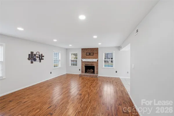 a view of a big room with wooden floor and fireplace
