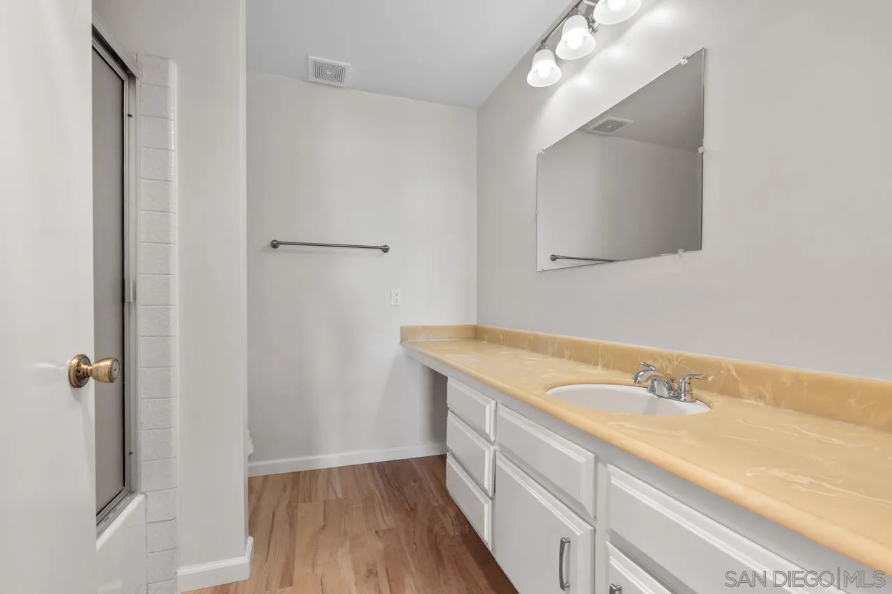 6747 Friars Road, Unit 110 San Diego, CA 92108 - Photo 13 of 24 a bathroom with a granite countertop sink a mirror and a shower
