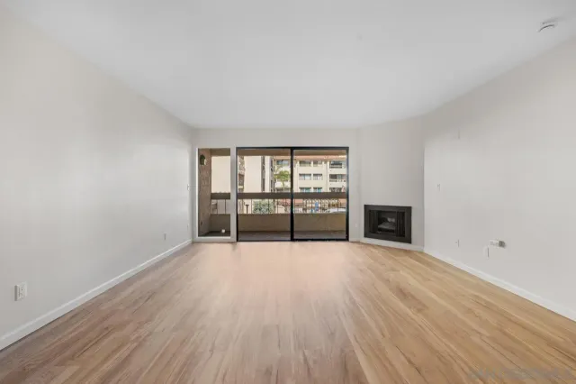 an empty room with wooden floor and fireplace