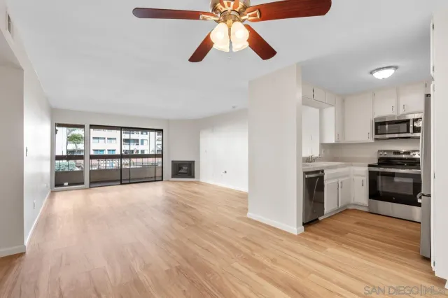 a view of a kitchen with wooden floor and a refrigerator